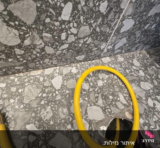 צינור צהוב על רצפת שיש אפורה